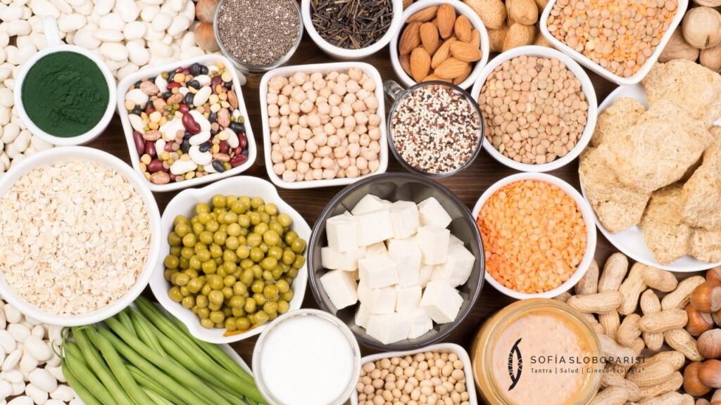 Variedad de alimentos vegetales con alto contenido proteico, como legumbres, tofu, frutos secos y cereales